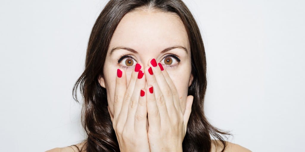 Beautiful woman with hands on face and red nails