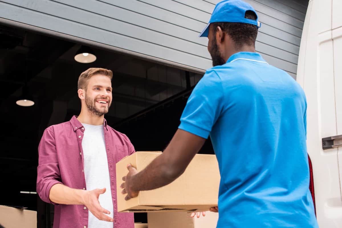 african american courier giving delivery box to customer
