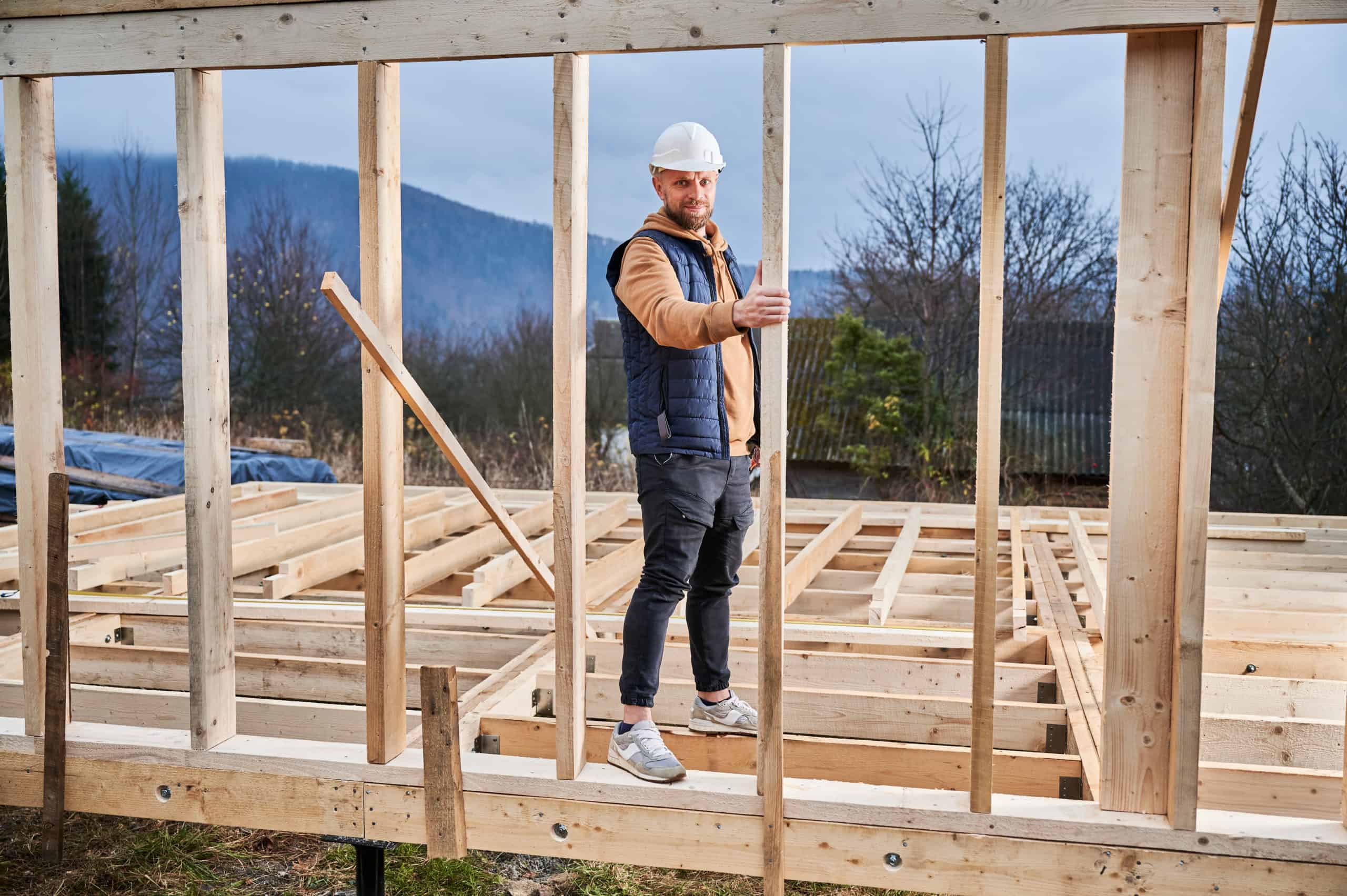 Man inspecting quality of building wooden frame house. Man inspecting quality of building wooden frame house.