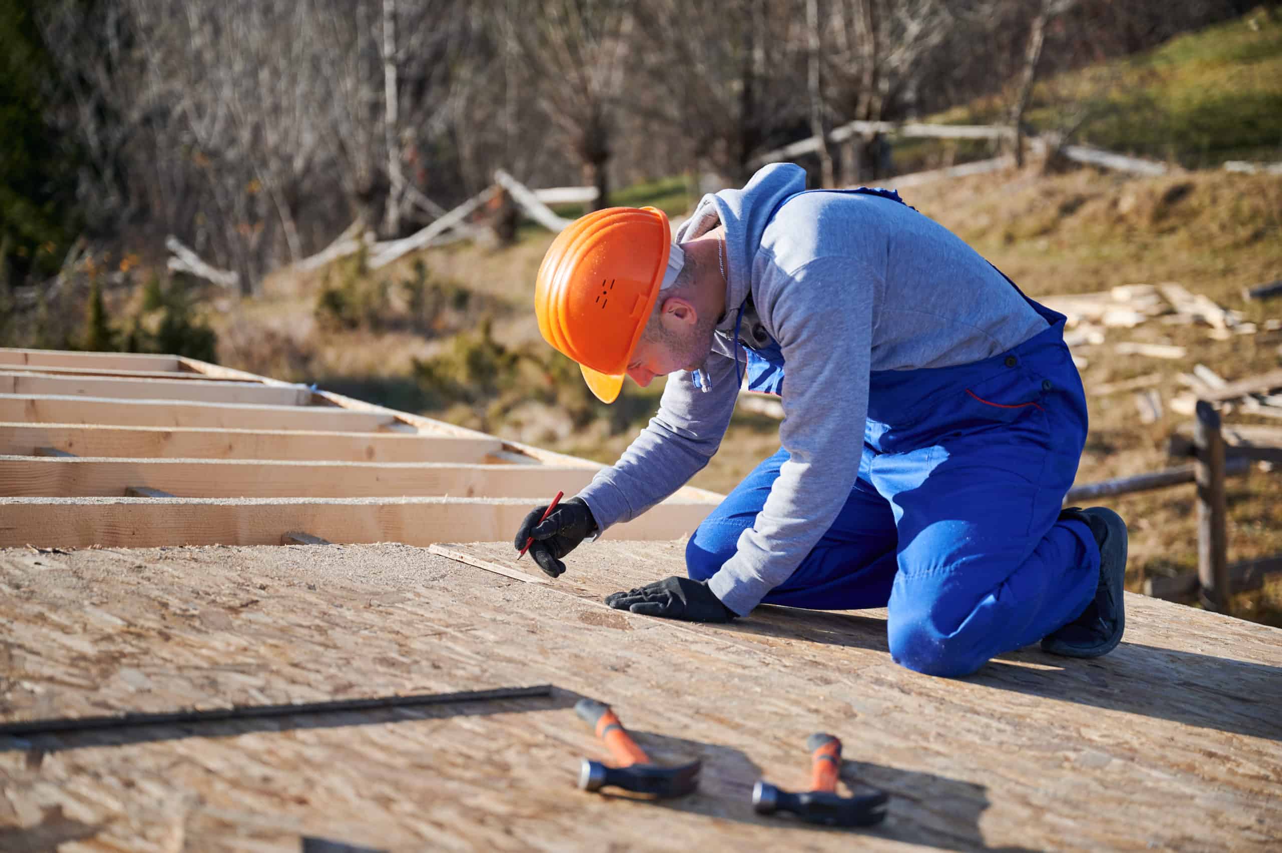 Man worker building wooden frame house on pile foundation. Man worker building wooden frame house on pile foundation.