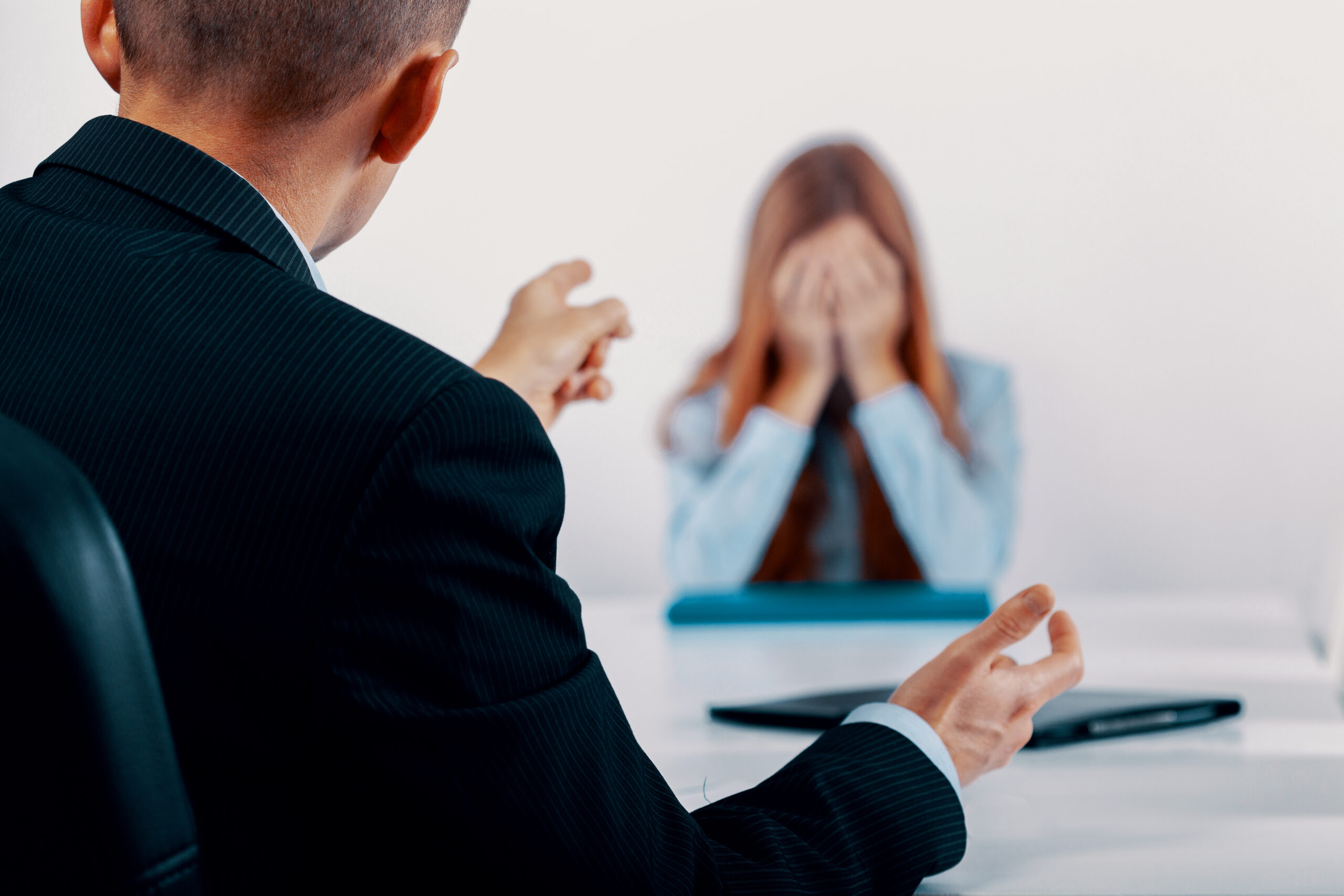 Depressed young woman during a conversation with the boss who points out her mistakes Depressed young woman during a conversation with the boss who points out her mistakes
