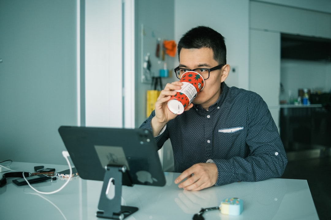 Man working on Ipad while drinking and searching about how to delete quora account Fast and Remove your data.