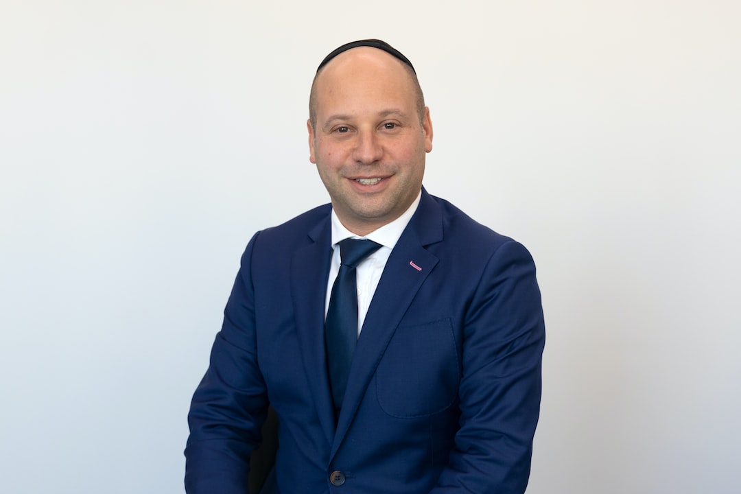 Handsome man sitting in a suit smiling at camera